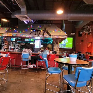 people sitting at tables in a sports bar