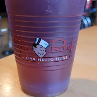 a plastic cup with a purple drink in it