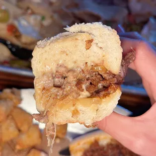 a hand holding a half eaten sandwich