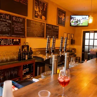 a bar with wine glasses on the bar