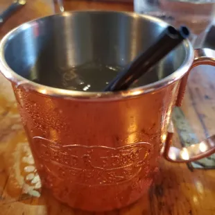 a copper mug with a spoon in it