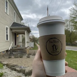 a hand holding a coffee cup