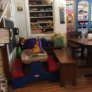 ows a playroom with a table, chairs, and toys