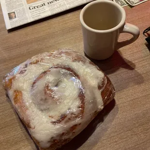 Cinnamon roll with coffee cup for size