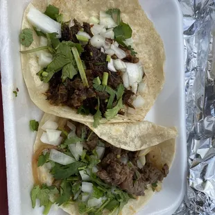 two tacos in a styrofoam container