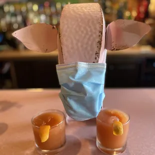 two glasses of cocktail and a mask