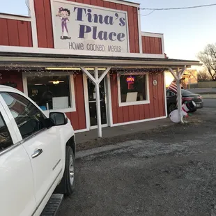 a white truck parked in front of a red building