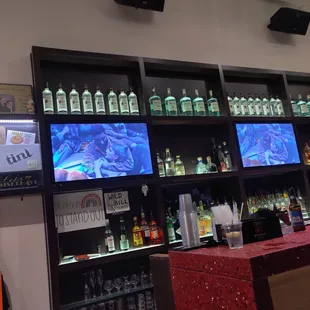a wall of liquor bottles and televisions
