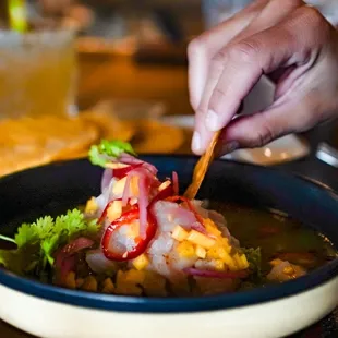 a person dipping something into a bowl