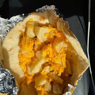 ows a burrito with cheese and potatoes