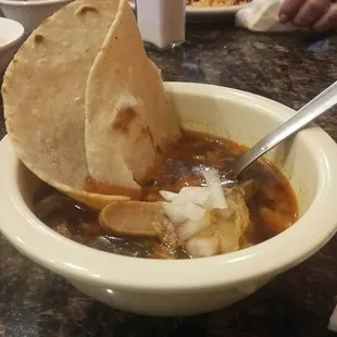 ows a bowl of soup with tortillas
