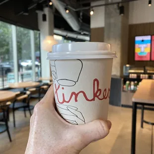 a hand holding a cup of coffee