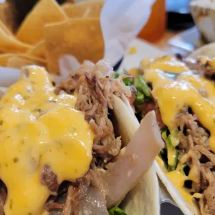 Carnitas tacos on flour tortillas.