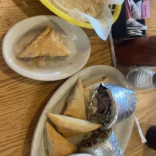 a plate of pita bread, pita chips, and dip sauce