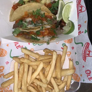 Two carne asada tacos, an Al pastor ant fries