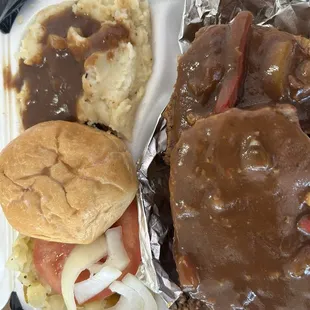 Meatloaf with gravy mashed potatoes cabbage with a tomatoe and onions