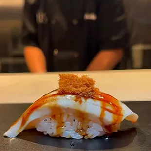 a sushi roll with sauce on it