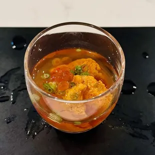 a bowl of soup on a black plate