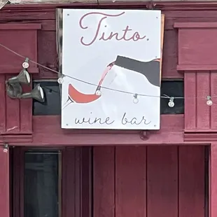 a wine bar sign on a red door
