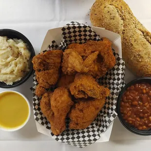 a basket of fried chicken, beans, and bread