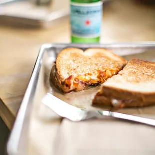 a half eaten sandwich on a tray