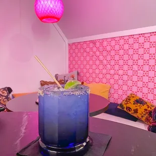 a blue cocktail with a lime garnish