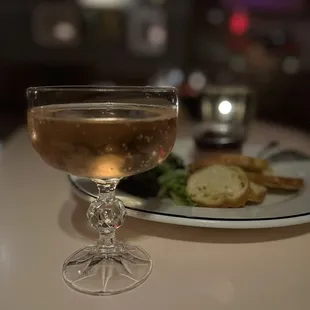 a glass of wine and a plate of bread