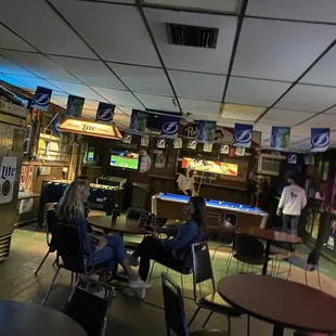 people sitting at tables and playing pool