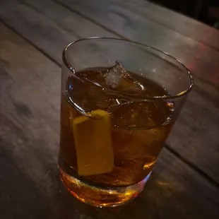 a glass of whiskey on a wooden table