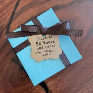 a blue gift box with a brown ribbon