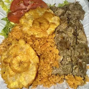 Dominican platter - rice, salad, roasted pork, and tostones.