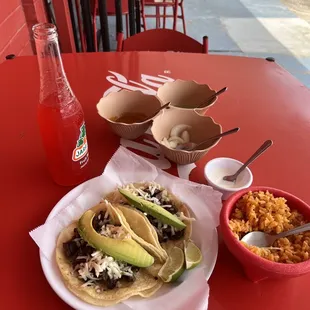 Two Fajita tacos with only cheese and avocado. A side of sour cream for my side of rice.