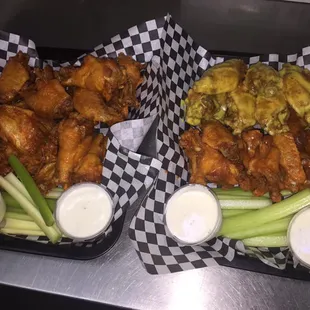two baskets of chicken wings and celery
