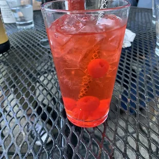 a red drink with ice and cherries