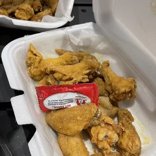 Chicken wings with hot sauce packet for size comparison.