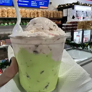 a hand holding a cup of ice cream