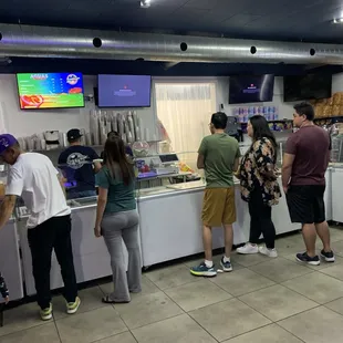a group of people standing in line at a counter