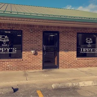 a brick building with a sign that says tippy's