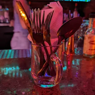 utensils in a glass on a bar counter