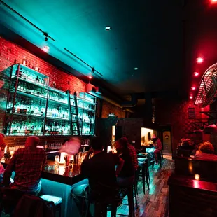 people sitting at a bar in a dimly lit room