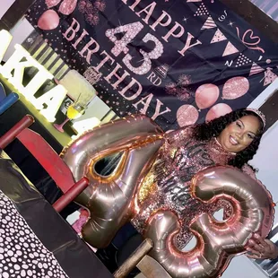 a woman sitting on a chair with a large balloon in the shape of an elephant