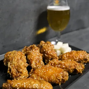 a glass of beer and a plate of wings