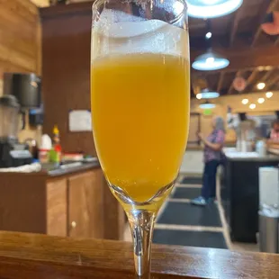 a glass of orange juice on a bar