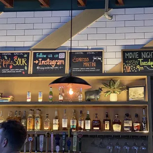 Behind the bar with specialty cocktail signs