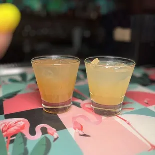 two glasses of drink on a table