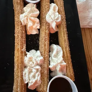 a plate of churros and dipping sauce