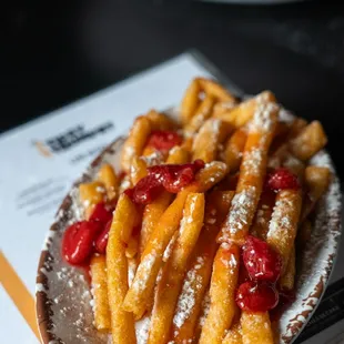 a plate of waffles with strawberries and powdered sugar
