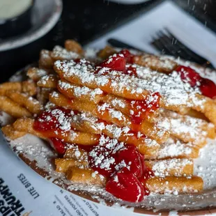 a plate of french fries covered in powdered sugar