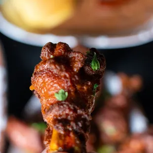 a hand holding a piece of fried chicken