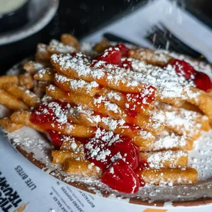 a plate of french fries covered in powdered sugar